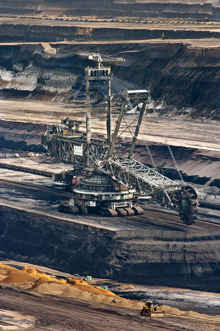 Large bucket-wheel excavator working the terraced benches of an open-pit mine